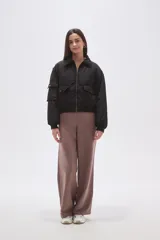 Campera tipo bomber color negro, con cierre frontal, cuello camisero, bolsillos frontales con solapa y puños elásticos.