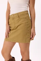 Falda corta de denim color marrón, de corte recto y tiro medio. Presenta detalle de tachas metálicas pequeñas a lo largo de las costuras laterales y cierre frontal con botón y cremallera.
