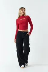 Top rojo de punto canalé, de manga larga y cuello alto con abertura en el pecho.