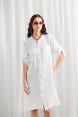 Túnica de lino color verde oliva, con cuello mao, cierre frontal con botones, bolsillos en el pecho y mangas largas con detalle de ajuste.