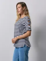 Remera de algodón a rayas horizontales blancas y negras, con cuello redondo y mangas cortas con aberturas entrelazadas.