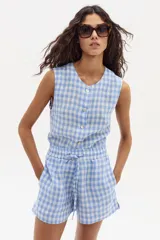 Short de lino con estampado vichy en tonos celeste y blanco, con cintura elastizada y cordón ajustable.