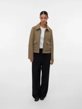 Campera estilo biker corta de punto interlock, con cuello camisero, cierre frontal metálico y bolsillos delanteros con solapa y broches a presión. Presenta un diseño estructurado y liviano sin forrería.