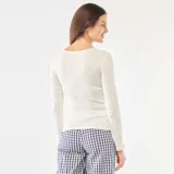 Camiseta de pijama de manga larga en color blanco, confeccionada en tejido de punto calado con textura sutil. Presenta un escote en V con borde delicado y una pequeña tapeta frontal con botones.