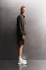 Sudadera relaxed fit gris claro melange de tejido ligero con mezcla de algodón, cuello subido, manga larga y cierre frontal con cremallera. Cuenta con bolsillos laterales ocultos y acabados en rib.
