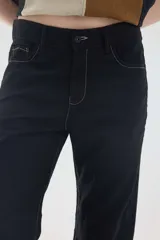 Pantalón de lino color beige, de corte recto y tiro medio, con bolsillos laterales y detalles de costuras visibles.
