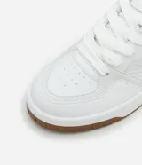 Championes blancos de cuero sintético con suela marrón de goma.