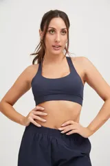 Top deportivo azul marino con tiras cruzadas en la espalda y elástico en la cintura.
