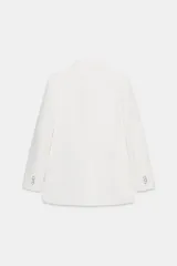 Blazer blanco de manga larga con cuello solapa y hombreras. Diseño cruzado con cierre frontal de cuatro botones y bolsillos delanteros con solapa.