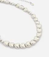 Collar corto de metal plateado con diseño de corazones tridimensionales en tamaños variados, superficie pulida y cadena extensible con cierre de mosquetón.