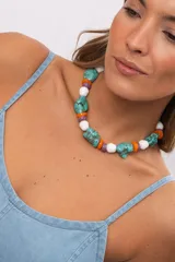 Collar corto compuesto por cuentas grandes de piedra turquesa irregular, alternadas con cuentas circulares blancas, naranjas y lilas.