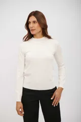 Polera de manga larga color blanco hueso, con cuello simulado (mock neck) y tejido de punto fino.
