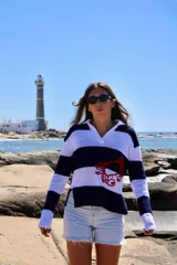 Sweater tejido de hilo de algodón a rayas horizontales blancas y azul marino, con cuello polo y bordado de un cangrejo rojo en el frente.