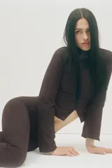 Pantalón de tiro alto con corte flare, entallado en la cintura y caderas, con bolsillos delanteros de vivo con cierre y trabillas para cinturón.