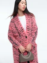 Saco largo de tejido de punto con textura peluda, estampado de cebra en tonos rosa y negro, con cierre frontal de un botón y capucha integrada.