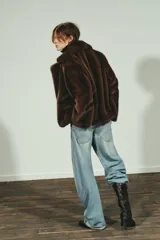 Abrigo corto de Zara con diseño de efecto pelo, cuello de solapa con muescas, manga larga y bolsillos frontales con solapa. Cuenta con forro interior a tono y cierre frontal con botón.