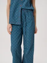 Pantalón de pierna recta de tiro alto con estampa geométrica y cintura elastizada. Presenta detalles y vivos en rojo en la cintura y costuras laterales.