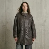 Chaqueta de cuero con acabado texturizado, corte recto y largo medio. Presenta cuello camisero, cierre frontal con cremallera y solapa con botones a presión, bolsillos laterales con solapa y puños ajustables con trabillas.