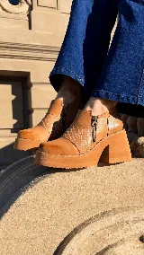 Zapatos de tacón alto y plataforma color camel, con inserción de cuero con textura en el empeine y doble cierre lateral decorativo.