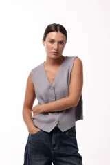 Chaleco tejido de punto con escote en V y cierre frontal con botones. Presenta una silueta recta y un diseño minimalista.