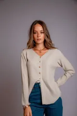 Blusa de morley elastizado color blanco, con escote en V y botones dorados.