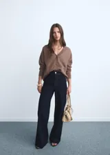 Jeans tiro alto de corte culotte y pierna ancha, en denim azul oscuro con bajo deshilachado, trabillas para cinto y bolsillos traseros.
