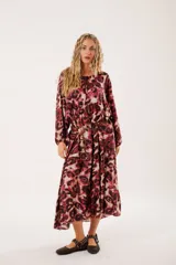 Vestido midi con estampado animal print en tonos borgoña y beige, con escote redondo y abertura en el pecho que se ajusta con lazos finos. De silueta relajada, manga larga tipo globo con terminación fruncida y falda amplia con recortes.