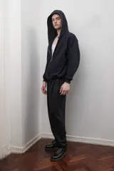 Campera negra con capucha, cierre metálico frontal, bolsillos laterales y corte oversize unisex.