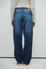 Pantalón de jean azul de corte recto y amplio, con tablas marcadas al frente y lavado azul con fuertes localizados.