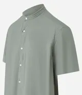 Camisa de manga corta, corte slim, color verde oliva con textura. Presenta cuello padre y cierre frontal de botones.
