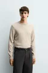 Sweater de punto regular fit fabricado en lana, color gris oscuro, con cuello redondo y manga larga. Cuenta con puños y cintura acanalados.
