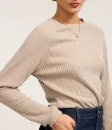 Blusa slim de tejido acanalado con cuello redondo y mangas largas con sisa raglán. Presenta una textura suave y diseño liso.