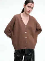 Cardigan de punto color marrón con textura jaspeada, escote en V, cierre frontal con botones y diseño de hombros caídos.