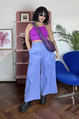 Pantalón sastrero de corte ancho y tiro alto, color celeste, con pinzas delanteras y cierre frontal con botón de acrílico.
