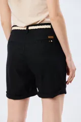 Bermuda de lino clásica color beige, de corte recto y tiro alto, con bolsillos laterales y vuelta en el ruedo. Incluye un cinto trenzado claro con detalles en marrón y hebilla metálica dorada.