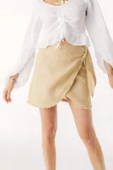 Minifalda color beige de lino, con corte cruzado y lazo lateral.