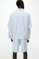 Short de felpa celeste de corte regular fit, con cintura elástica y cordón ajustable. Cuenta con bandas laterales blancas con el logo de Lotto repetido, bolsillos laterales y el logo de la marca bordado en una pierna.