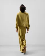 Falda larga verde oliva satinada con cinturilla elástica interior, cierre de cremallera lateral, corte al bies y bajo evasé.