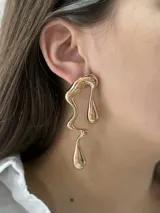 Aros colgantes dorados con diseño abstracto irregular.