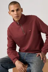 Buzo de algodón color bordó con cuello alto y cierre frontal parcial de un cuarto. Presenta un diseño liso con el logo de la marca bordado en pequeño en el pecho.