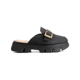 Zueco tipo mule de color negro, con capellada de textura suave y detalle de hebilla metálica dorada en el empeine. Presenta una suela track de plataforma dentada, brindando un estilo moderno y cómodo.