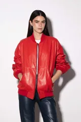 Campera bomber de cuero vacuno en color bordó, con diseño oversized y corte bombé. Presenta cierre frontal, bolsillos laterales y terminaciones de puños, cuello y pretina en tejido de algodón acanalado a tono.