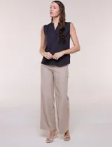 Blusa de gasa sin mangas de calce holgado, marca Sioni. Cuenta con cuello cadete, abertura frontal en V con media cartera de botones, espalda con canesú y pliegue central, y ruedo redondeado.