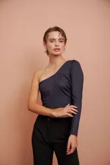 Top corto negro de un hombro con manga larga ajustada.