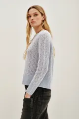 Sweater de punto calado con diseño de ondas, cuello redondo y mangas largas con puños acanalados.
