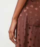 Blusa sin mangas color marrón con estampado de hojas, cuello de pico y textura jacquard.