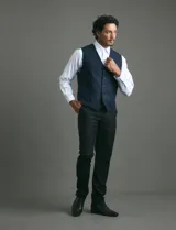 Chaleco de vestir color azul oscuro con textura sutil, corte clásico, cierre frontal con botones y bolsillos laterales simulados.