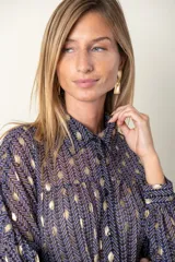 Camisa de gasa plisada color violeta con estampado de círculos dorados, de corte holgado y manga larga.