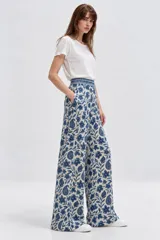 Pantalón ancho de algodón con cintura alta y bolsillos laterales, con estampado floral en tonos azules sobre fondo claro.