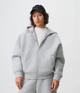 Campera boxy de malla scuba color gris melange, con capucha, cierre frontal completo y bolsillos laterales ocultos.